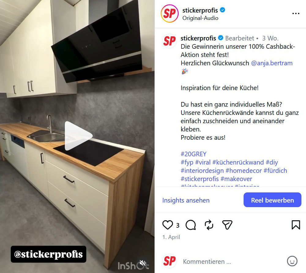 Instagram-Feed mit von einer K&uuml;che mit einer K&uuml;chenr&uuml;ckwand im grau melangierten Motiv 20GREY und silberner Armatur und einer Arbeitsplatte aus Holz mit elfenbein wei&szlig;en K&uuml;chenfronten