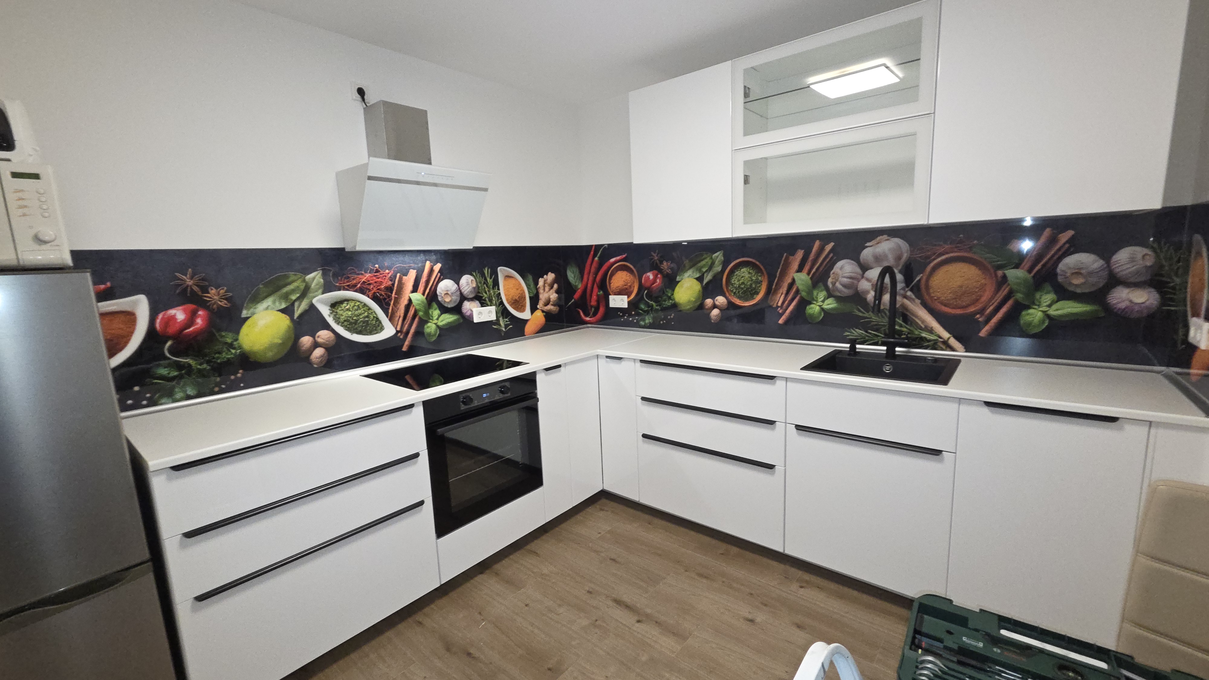 Wei&szlig;e K&uuml;che die mit einer selbstklebenden K&uuml;chenr&uuml;ckwand mit Gew&uuml;rzschalen Motiv verklebt ist